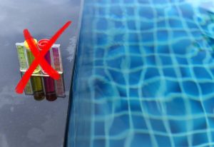 produits chimique au bord de la piscine avec croix rouge qui barre les produits